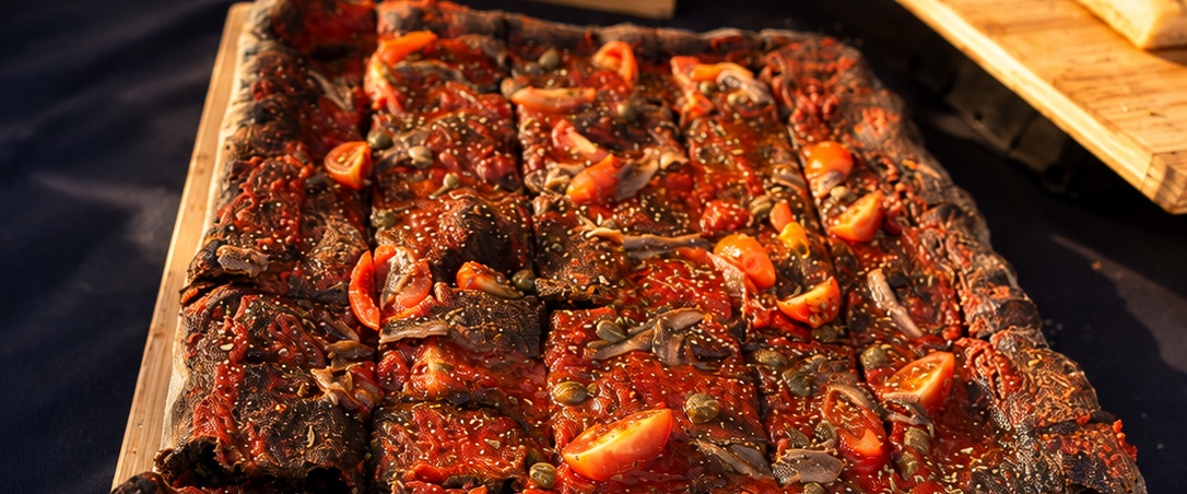 Pizza al metro con tomate, alcaparras y anchoas